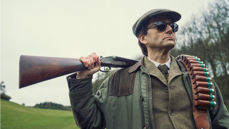 David Tennant as Lord Tony Baddingham with a shotgun and sunglasses in Rivals