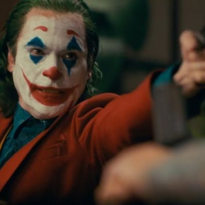 Joaquin Phoenix as Joker with a gun